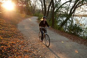 Late afternoon sunlight backlights a person biking along the Howard Temin Lakeshore Path at the University of Wisconsin-Madison during autumn on Oct. 13, 2010. (Photo by Jeff Miller/UW-Madison)