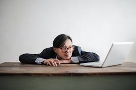 Bored formal man watching laptop at desk · Free Stock Photo